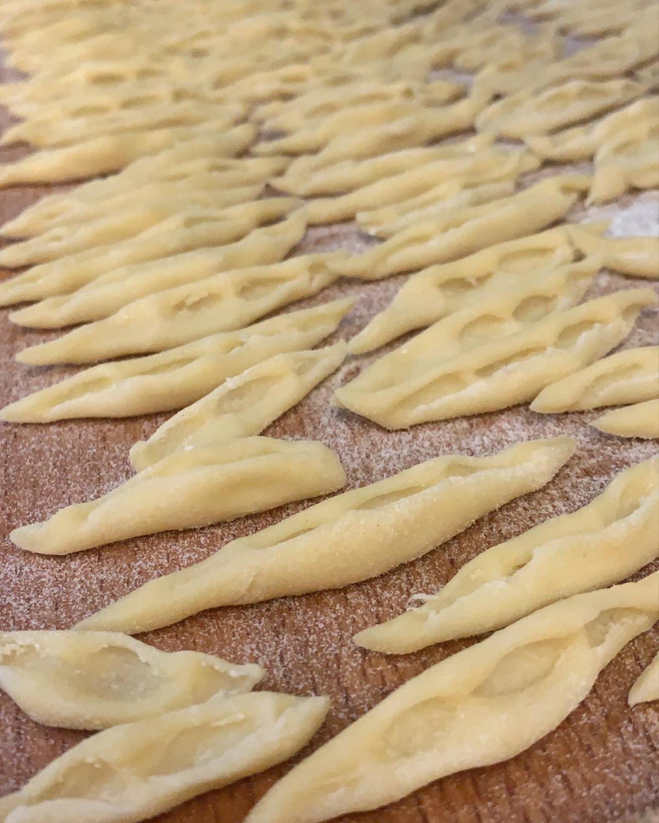 Frisch gedrehte hausgemachte Pasta auf einem bemehlten Holzbrett